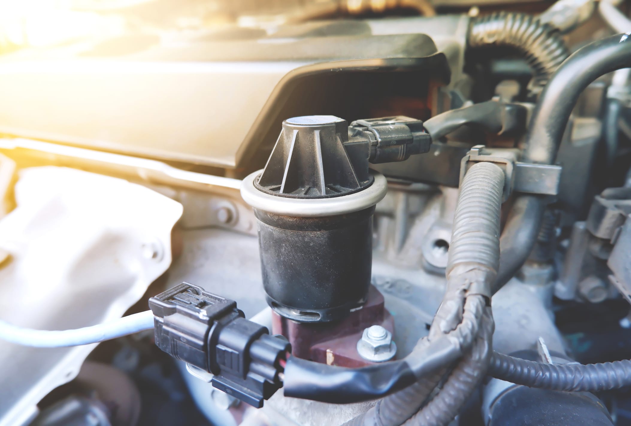 Close up of the exhaust gas recirculation system in the car engine compartment to reduce the amount of carbon monoxide gas coming from the exhaust.