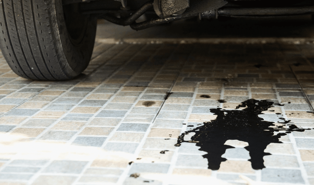 An oil leak under a parked car. The oil is black.