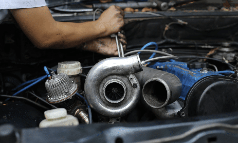 Mechanic working on a car turbocharger.